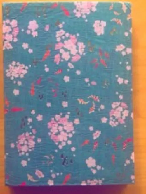 Buch mit Blumenmuster auf Holztisch.