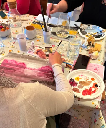 People painting on a flower-patterned table.