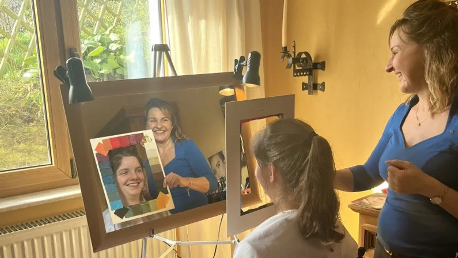 Two people smiling in a room with mirror.