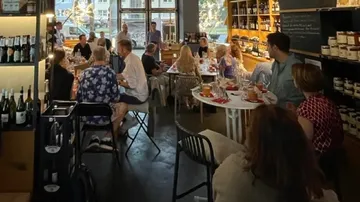 Personen essen in einem gemütlichen Weingeschäft.