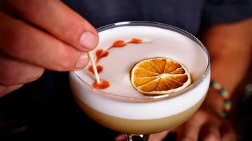 Cocktail mit Garnierung wird mit Zahnstocher verziert.