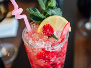 Colourful drink with ice cream, berries and mint on table.