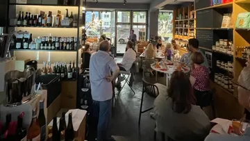 People dining in a cozy, wine-filled restaurant.