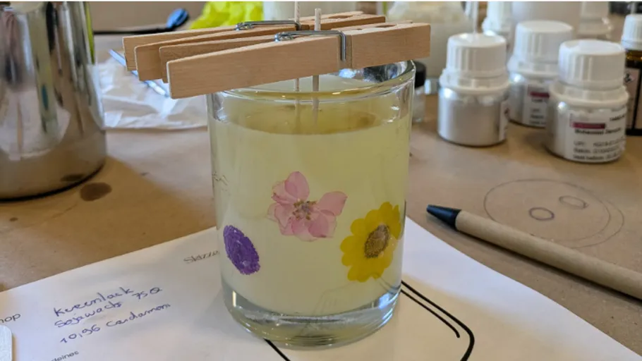 Glass candle with clothespin wick holder.