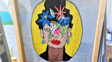 Buntes Wandteppichporträt mit Blumen auf Stoff.