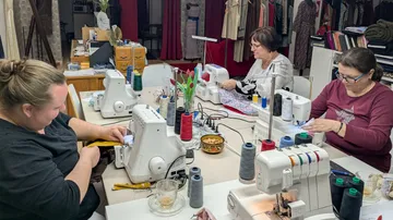 People using sewing machines in a workshop.