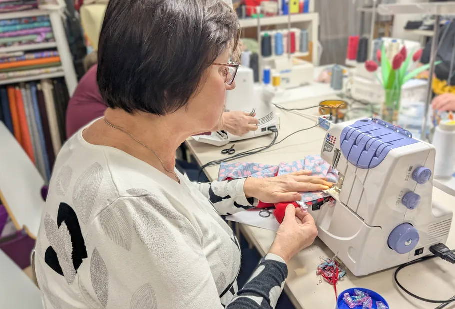 Woman using sewing machine in workshop.