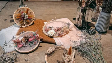 Floral embroidery hoops on wooden table.