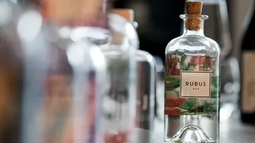 Flasche Rubus-Gin auf Tisch mit anderen.