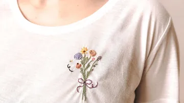 White shirt with embroidered flower design.