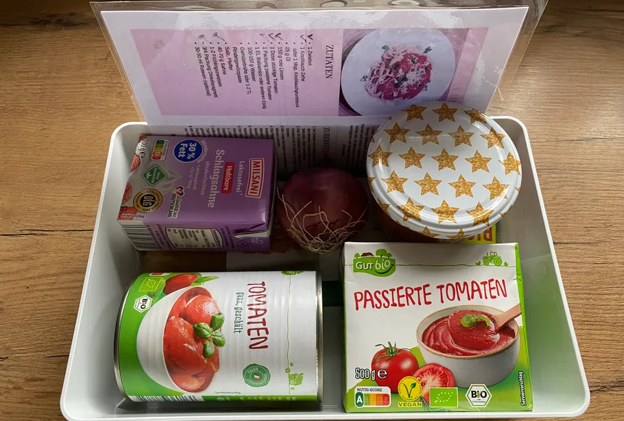 Box with cooking ingredients and recipe card.