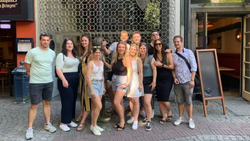 Gruppe von Personen posiert vor einem Restaurant.