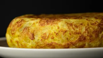 Goldenes spanisches Omelett auf weißem Teller.