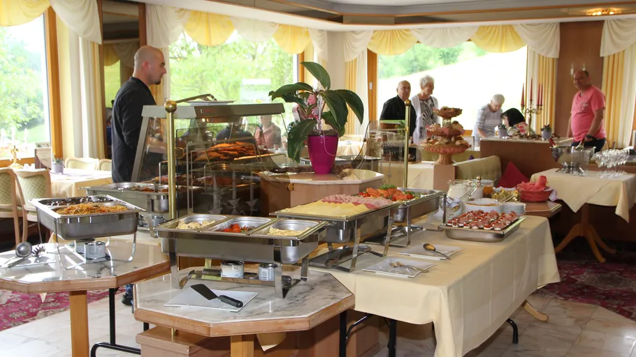 Buffet with food trays in restaurant setting.