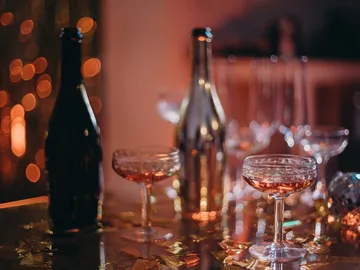 Flaschen und Gläser stehen auf einem festlichen Tisch.