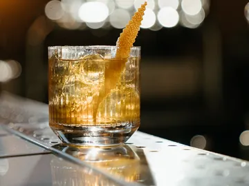 Eiskalter Cocktail steht auf einer glänzenden Bartheke.