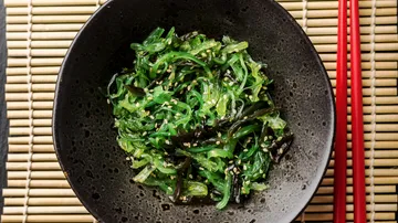 Algensalat mit Sesam in schwarzer Schale.