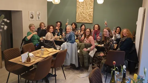 Gruppe stößt mit Wein im Restaurant an.