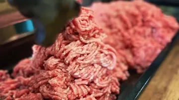 Ground meat piled on a tray indoors.