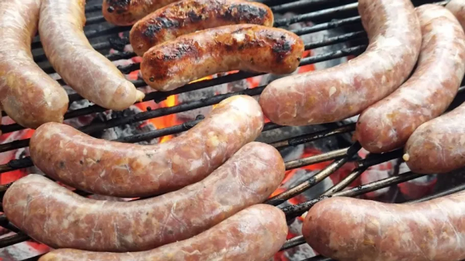 Würste grillen über heißen Kohlen auf Grill.