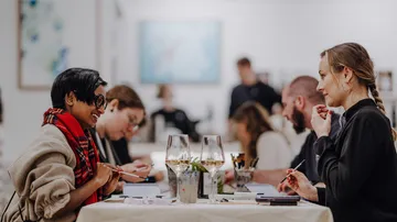 People sitting at table, enjoying drinks, socializing.
