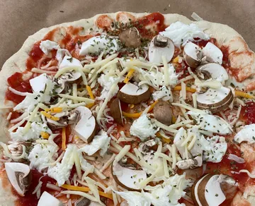 Ungebackene Pizza mit Käse, Pilzen, Tomatensauce.
