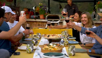 Gruppe stößt mit Wein beim Abendessen an.