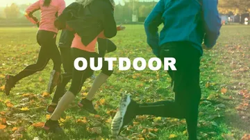 People running on grassy field outdoors.