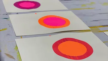 Bunte Kreise auf weißem Papier gemalt.