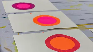 Colorful circle patterns on white paper sheets.