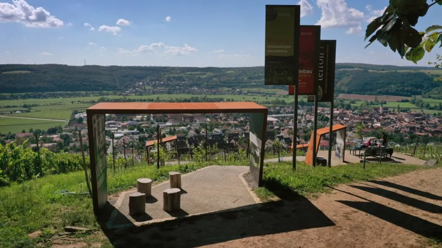 Viewpoint with benches overlooking a village landscape.