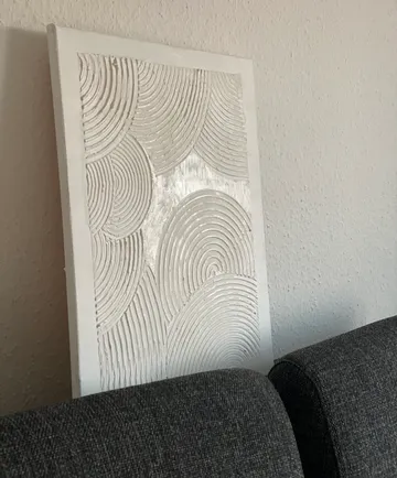 Textured painting leaning against a wall.