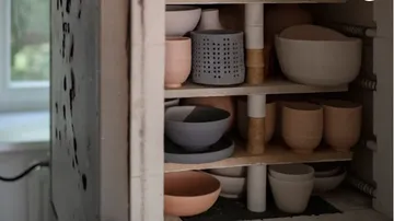 Ceramic bowls and cups inside a kiln.