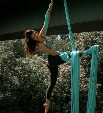 Woman performing aerial silk outdoors.