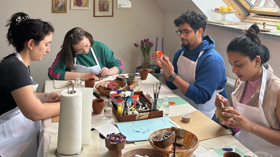 People painting Easter eggs at indoor table.