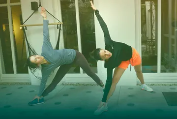 Two people doing yoga poses outdoors.