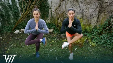 Zwei Frauen üben Yoga im Garten.