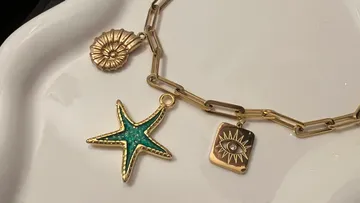 Goldenes Armband mit Seestern, Muschel, Auge Anhängern.