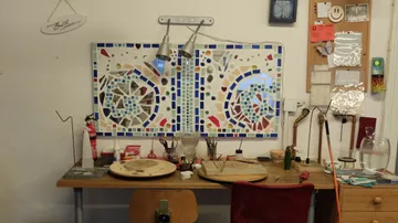 Werkbank mit buntem Mosaik an der Wand.