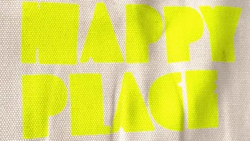 Bright lettering saying 'HAPPY PLACE' on fabric.