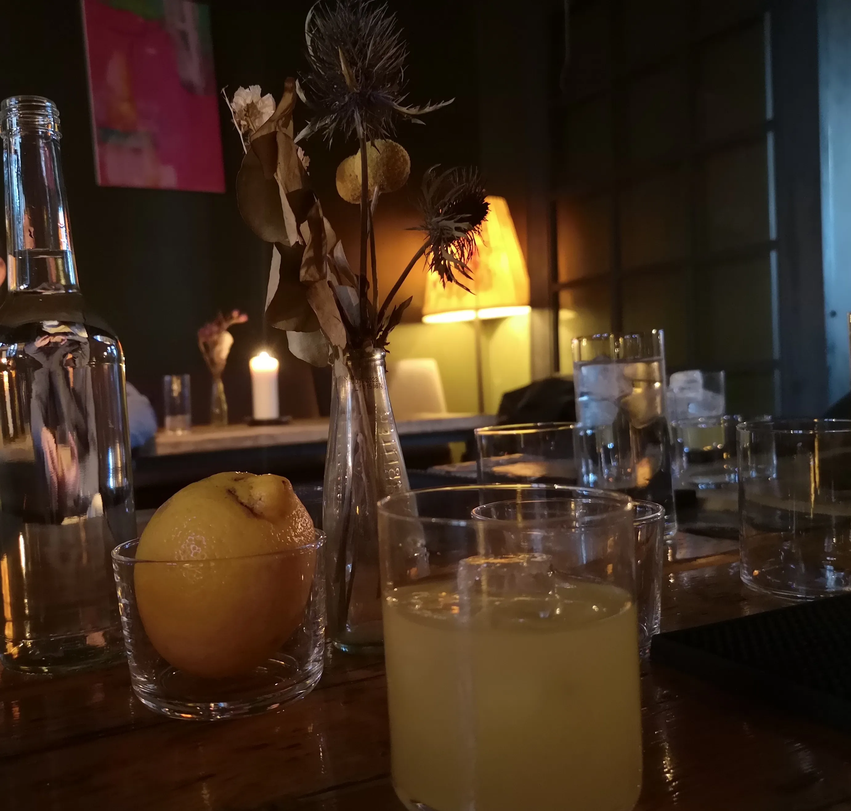 Lemon and drinks on dimly-lit table.