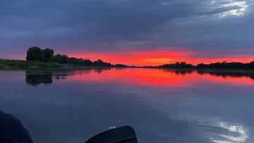 River reflecting a vibrant sunset sky.