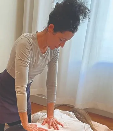 Woman performing massage in bright room.