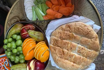 Fruits, vegetables, and bread on a tray.