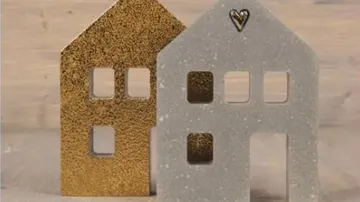 Two decorative house figures on wooden surface.