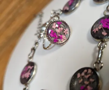Ring mit pinkfarbenen Blumen im Glaskabochon.