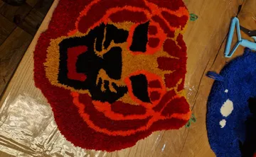 Bunter getufteter Löwenkopf auf Holztisch.
