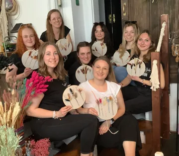 Group of women holding decorative crafts indoors.