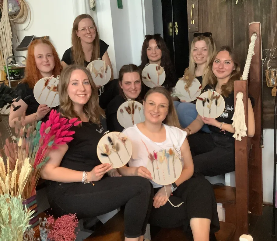 Group of women holding decorative crafts indoors.