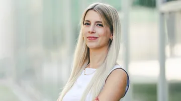 Lächelnde Frau mit langen Haaren im Freien.